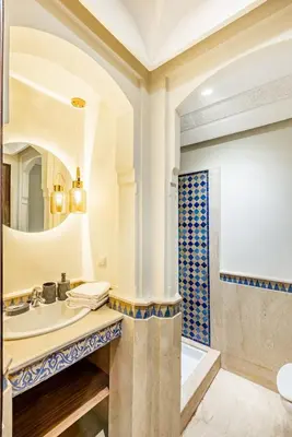 a bathroom with a sink and a tub and a mirror at Suite Moderne Deluxe Miracle, à Babylone, Hyper-Centre, Marrakesh in Marrakech