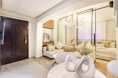 a living room with two couches and a table at Suite Moderne Deluxe Miracle, à Babylone, Hyper-Centre, Marrakesh in Marrakech