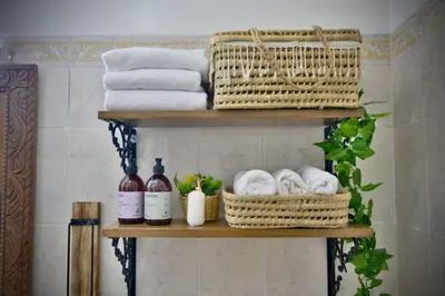 a shelf with towels and baskets and bottles of wine at Dar Kech Luxury et comfort in Marrakech
