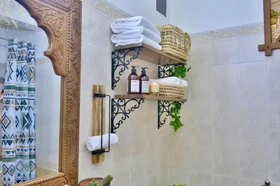 a bathroom with a shower with towels and a mirror at Dar Kech Luxury et comfort in Marrakech
