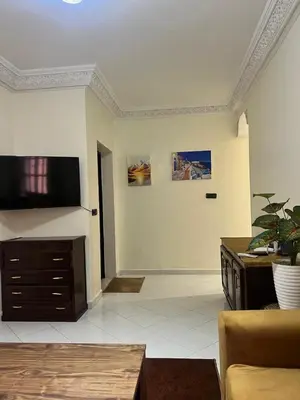 a living room with a couch and a flat screen tv at Bel Appart 2 chambres à 10 min à pied de RAK in Marrakech