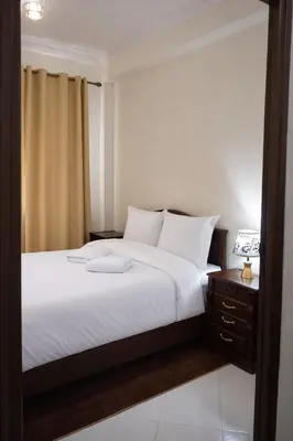 a bedroom with a bed with white sheets and a nightstand at Bel Appart 2 chambres à 10 min à pied de RAK in Marrakech