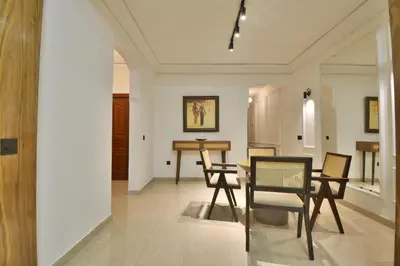 a living room with a dining room table and chairs at L'adresse- Appartement 4p au centre de Marrakech in Marrakech