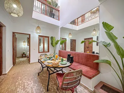 a living room with a table and a couch at Riad Louzaia, Marrakech in Marrakech
