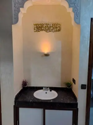 a bathroom with a sink and a light on a wall at house mohamed in Marrakech