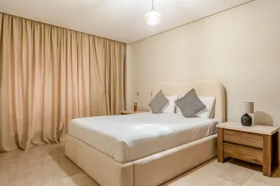 a bedroom with a large white bed with two pillows at Gueliz apartment with pool, spa and gym in Marrakech