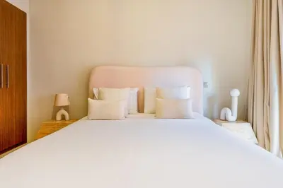 a white bed with white pillows in a bedroom at Gueliz apartment with pool, spa and gym in Marrakech