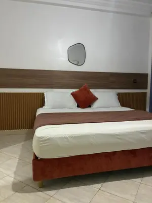 a bedroom with a large bed with a wooden headboard at the wonder of Marrakesh in Marrakech