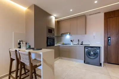a kitchen with a washing machine and a table and chairs at palace studio gueliz et proche gare central in Marrakech