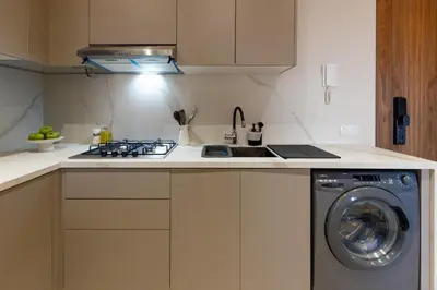 a kitchen with a stove and a washing machine at palace studio gueliz et proche gare central in Marrakech