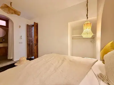 a bedroom with a bed and a chandelier at Kasbahbibi pool breakfast city center private in Marrakech