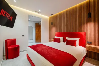 a bedroom with a red and white bed and a tv at Confort Haut de Gamme au Coeur de la Ville in Marrakech