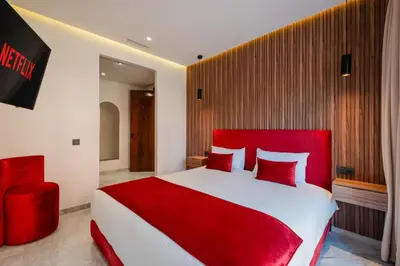 a bedroom with a red bed and a red chair at Confort Haut de Gamme au Coeur de la Ville in Marrakech