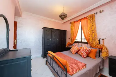 a bedroom with a bed with orange and orange pillows at DarSaouiri55 in Marrakech