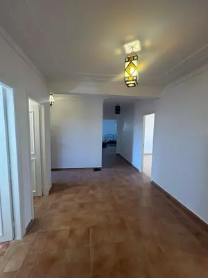 an empty room with white walls and a chandelier at Appartement 3 Chambres 140 m Najd, Calme & Confort in Marrakech