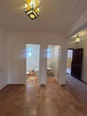 an empty living room with a chandelier on the ceiling at Appartement 3 Chambres 140 m Najd, Calme & Confort in Marrakech