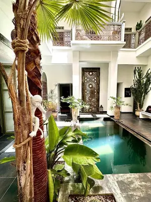 a villa with a swimming pool and a palm tree at Riad 191 - Maison privée, spa & piscine in Marrakech