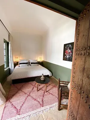 a bedroom with a large bed and a table at Riad 191 - Maison privée, spa & piscine in Marrakech