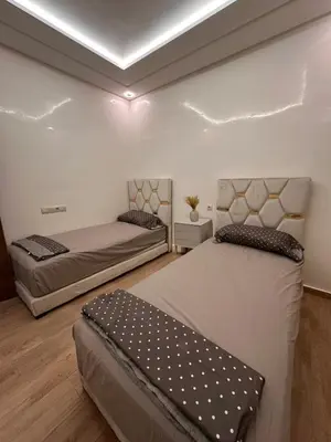 a bedroom with two beds and a ceiling at Appartement luxueux au centre in Marrakech