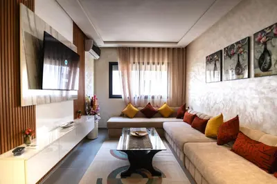 a living room with a couch and a table at Oasis Urban avec Balcon - 5min de l'aéroport in Marrakech