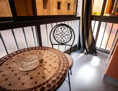 a table and a chair on a balcony at Oasis Urban avec Balcon - 5min de l'aéroport in Marrakech