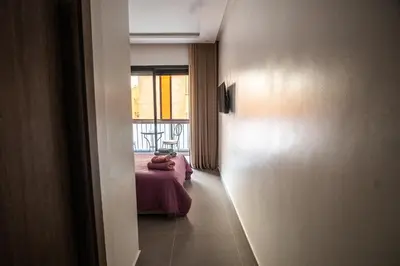 a room with a bed and a window at Oasis Urban avec Balcon - 5min de l'aéroport in Marrakech