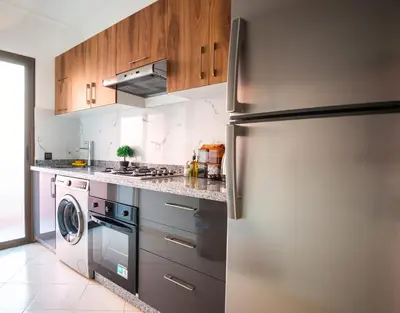 a kitchen with a refrigerator and a washer and dryer at Haven Cosy avec Piscine in Marrakech