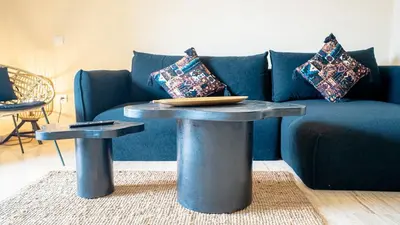 a living room with a blue couch and a table at Appartement moderne terrasse avec baignoire privée in Marrakech