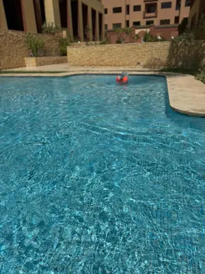 a swimming pool with blue water in a building at Appartement moderne terrasse avec baignoire privée in Marrakech