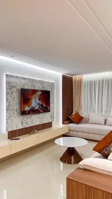 a living room with a couch and a tv on a wall at Appartement luxueux avec piscine in Marrakech
