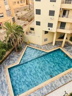 an overhead view of a swimming pool in front of a building at Appartement luxueux avec piscine in Marrakech
