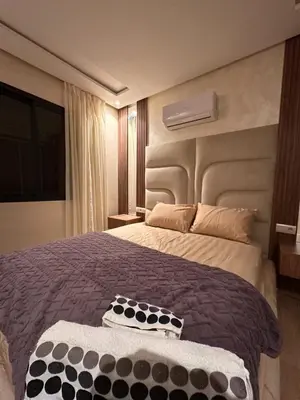 a bedroom with a large bed with a large headboard at Appartement luxueux avec piscine in Marrakech
