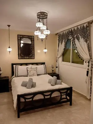 a bedroom with a large bed with a chandelier at Kasbah Bastoff in Marrakech