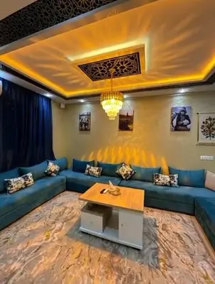 a living room with a blue couch and a table at appartement airport Marrakech in Marrakech