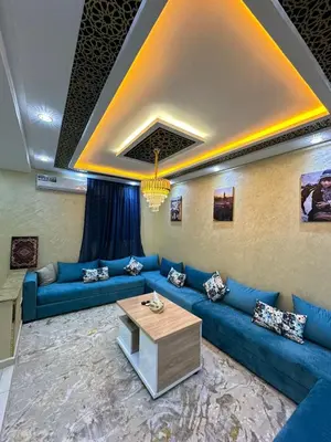 a living room with blue couches and a table at appartement airport Marrakech in Marrakech