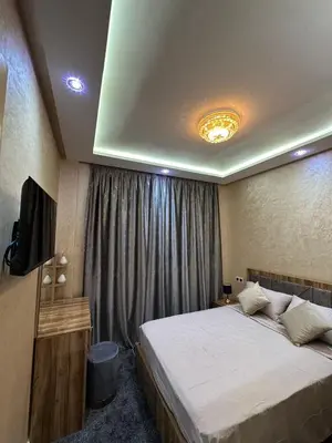 a bedroom with a large bed and a television at appartement airport Marrakech in Marrakech
