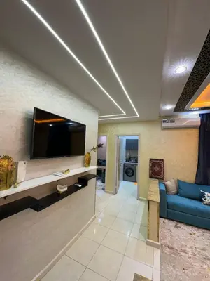 a living room with a blue couch and a tv at appartement airport Marrakech in Marrakech