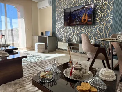 a living room with a table and a tv at appartement de luxe dans le centre de marrakech in Marrakech