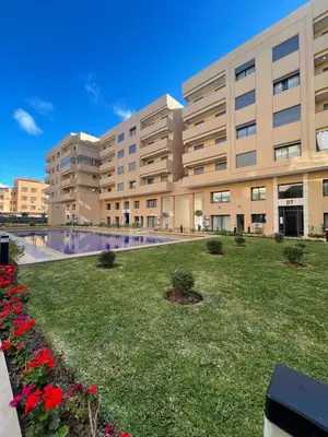 a large building with a lawn in front of it at Elegant 2 bedroom apartment in Palmeraie Gates in Marrakech