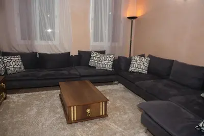 a living room with a black couch and a coffee table at Calm Spacious Family Apartment Close To Coty in Marrakech