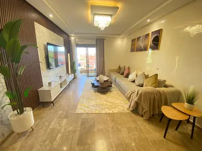 a living room with a couch and a table at Small Cosy & Balcon & Vue Palmier et Montagne in Marrakech