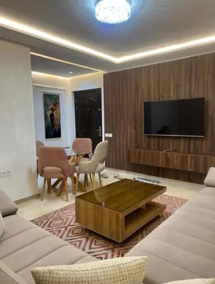 a living room with a couch and a tv at Jennaya - Appartement moderne, élégant et raffiné in Marrakech