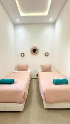 two beds in a room with a mirror on the wall at New Villa Dali & Spa Paddel Marrakech in Marrakech