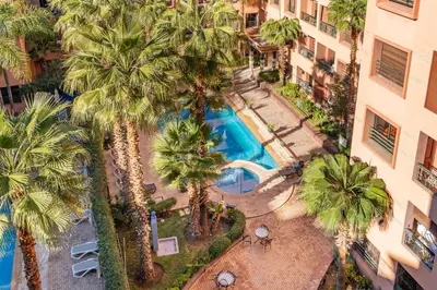an overhead view of a swimming pool with palm trees at Cocon Ocre Pool and Balcony in Marrakech