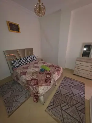 a bedroom with a bed with a quilt and two rugs at appartement lady Plaza 2 in Marrakech