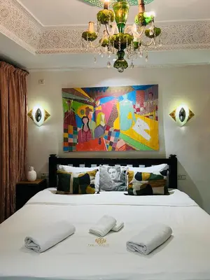 a bedroom with a large white bed with a chandelier at Riad Dar L artiste in Marrakech