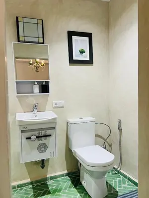 a bathroom with a white toilet and a sink at Riad Dar L artiste in Marrakech