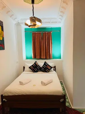 a bedroom with a bed with a green headboard at Riad Dar L artiste in Marrakech
