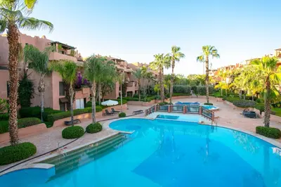 a large swimming pool with palm trees and buildings at Your Unique Stay - Marrakech Place To Be in Marrakech
