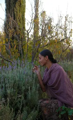 a woman standing in a garden looking at purple flowers at Daba Village in Marrakech